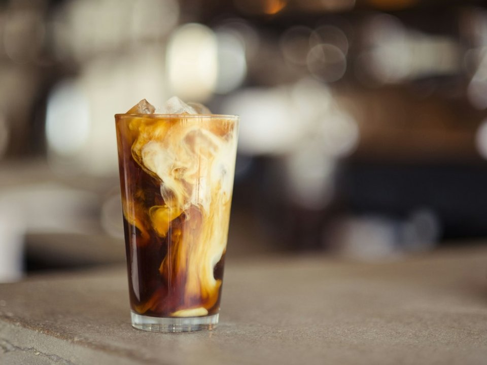Iced cold coffee with milk swirl